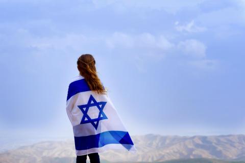 Girl wrapped in Israeli Flag overlooking Israel 